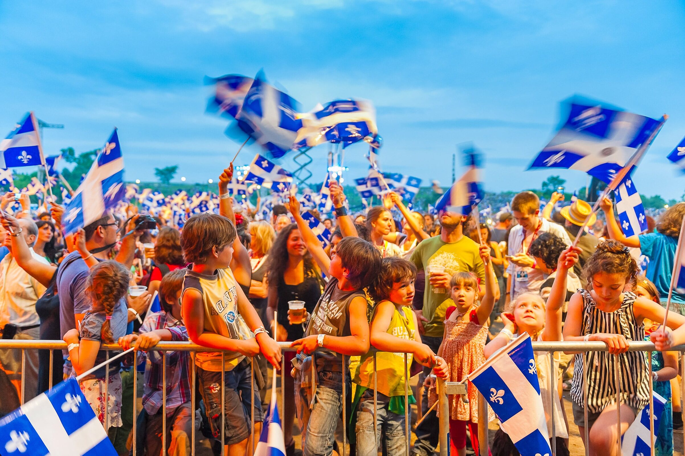 quebec festival with children and their parents waving flags