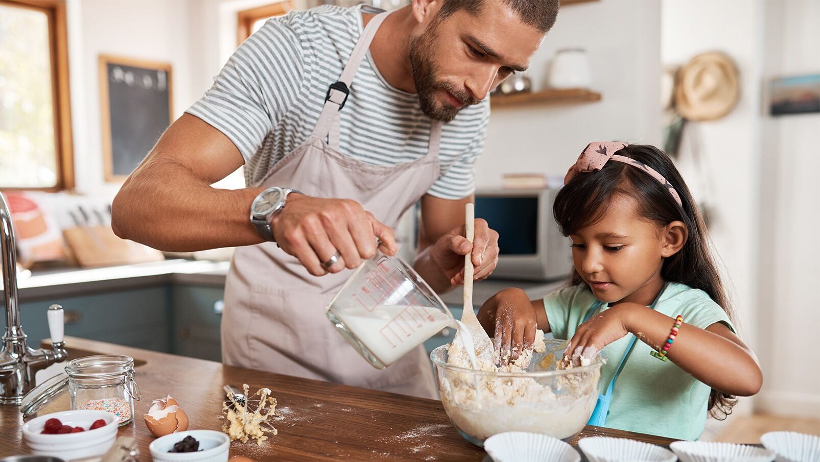 daughter and father mixing batter in a bowl