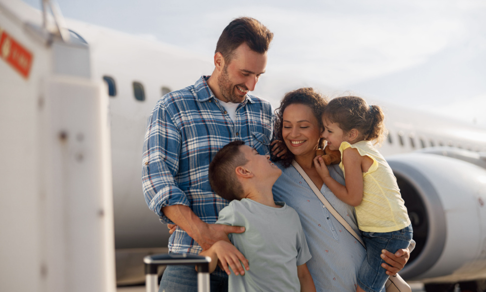 family holding each other while standing next to airplane