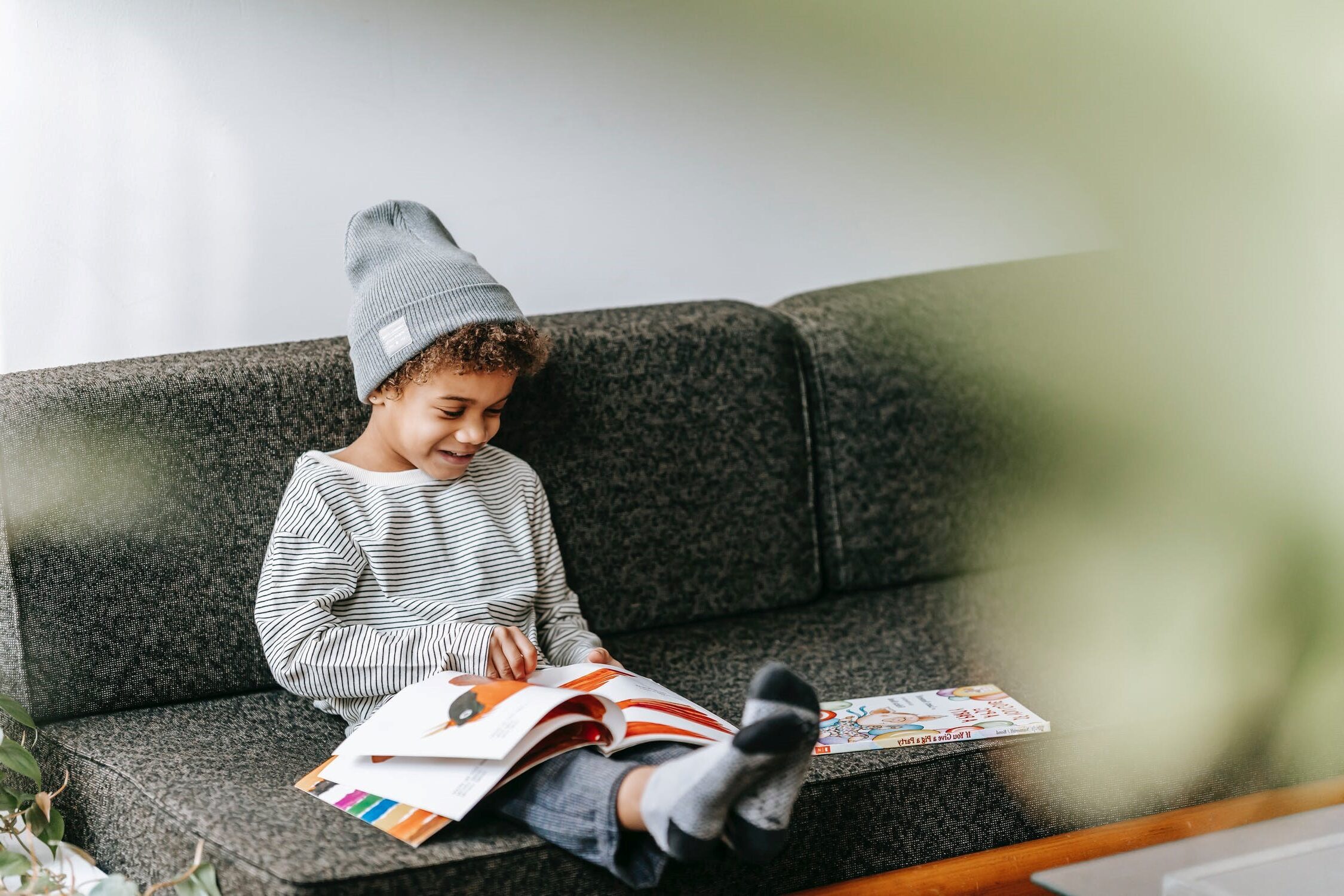 child sitting on couch looking at book with spanish words