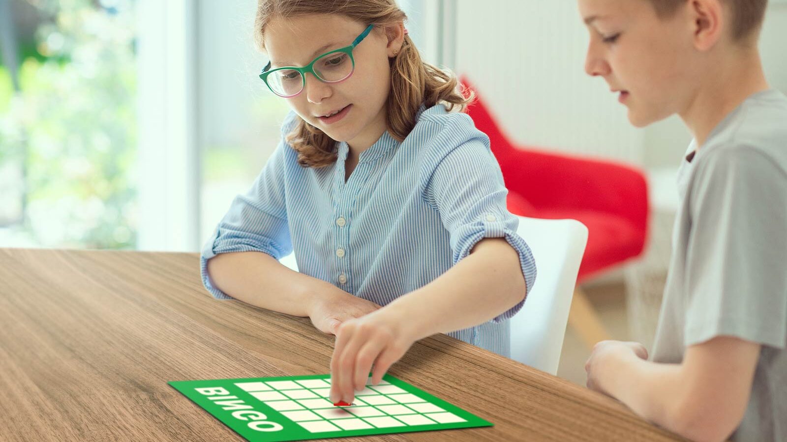 two children playing french bingo on dining room table