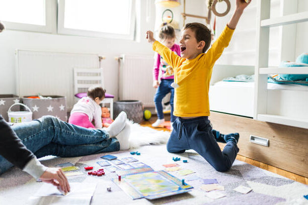 children playing spanish board games in the living room on the floor with their parents